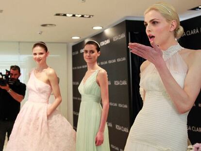 El modelo andrógino Andrej Pejic (derecha) posa vestido de novia junto a otras dos modelos en la Barcelona Bridal Week.