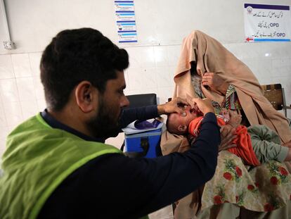 Un trabajador sanitario pakistaní administra gotas antipoliomielíticas a un niño durante una campaña de vacunación en el hospital público Lady Reading de Peshawar (Pakistán), el 2 de octubre.