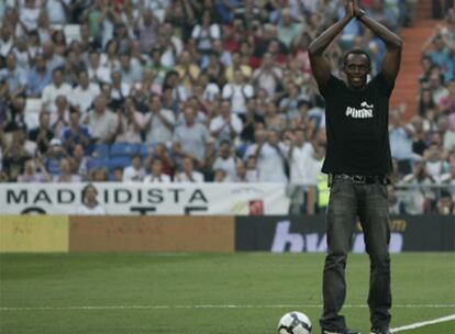 Usain Bolt saluda a la hinchada del Bernabéu momentos antes de hacer el saque de honor.