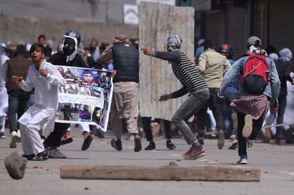 Manifestantes lanzan piedras hacia la policía india durante los enfrentamientos después de las oraciones del Eid al-Fitr en Srinagar.