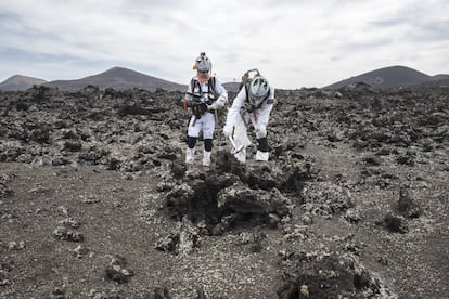Dos astronautas ensayan en un campo de lava canario la recogida de muestras.