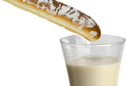 Un farton a punto de ser mojado en un vaso de horchata.