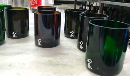 Vasos obtenidos con la base de las botellas que sirven como platos. 