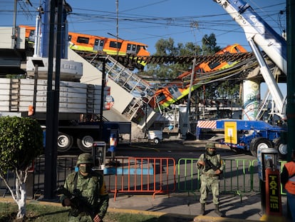 Una grúa maniobra para levantar el vagón caído al romperse una viga de la línea 12 del metro de Ciudad de México, este martes.