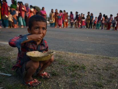 Un nen menja arròs en un camp de refugiats nepalesos.