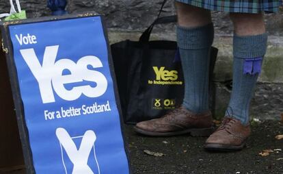 Un hombre a favor de la independencia de Escocia, junto a un cartel a favor del sí.
