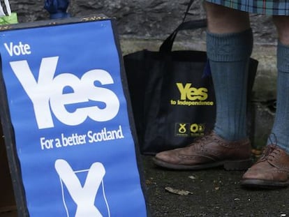 Un hombre a favor de la independencia de Escocia, junto a un cartel a favor del s&iacute;. 