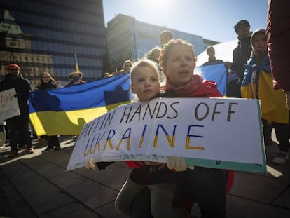 Una mujer y un niño asisten a una manifestación en apoyo del pueblo de Ucrania en Vancouver, Columbia Británica. 