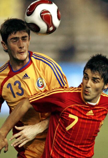 David Villa pelea un balón con el jugador de la selección rumana Cocis.