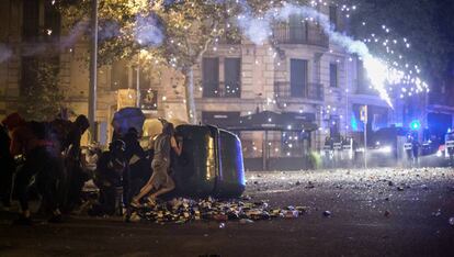 Manifestantes y Mossos d'Esquadra se enfrentan durante el lanzamiento de una bengala. 