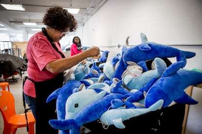 Una costurera cose a mano los peluches del tapizado de la silla Delfines y Tiburones.