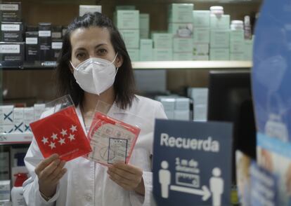 A pharmacist holds one of the face masks that have been distributed for free by the Madrid regional government.