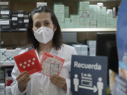 Una farmacéutica en la Farmacia CEA muestra una mascarilla del anterior reparto.