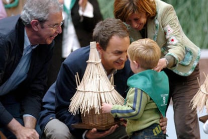 José Luis Rodríguez Zapatero; el candidato del PSdeG a la Xunta de Galicia, Emilio Pérez Touriño, y la ministra de Agricultura y Pesca, Elena Espinosa, saludan a un niño ayer en Santiago de Compostela.