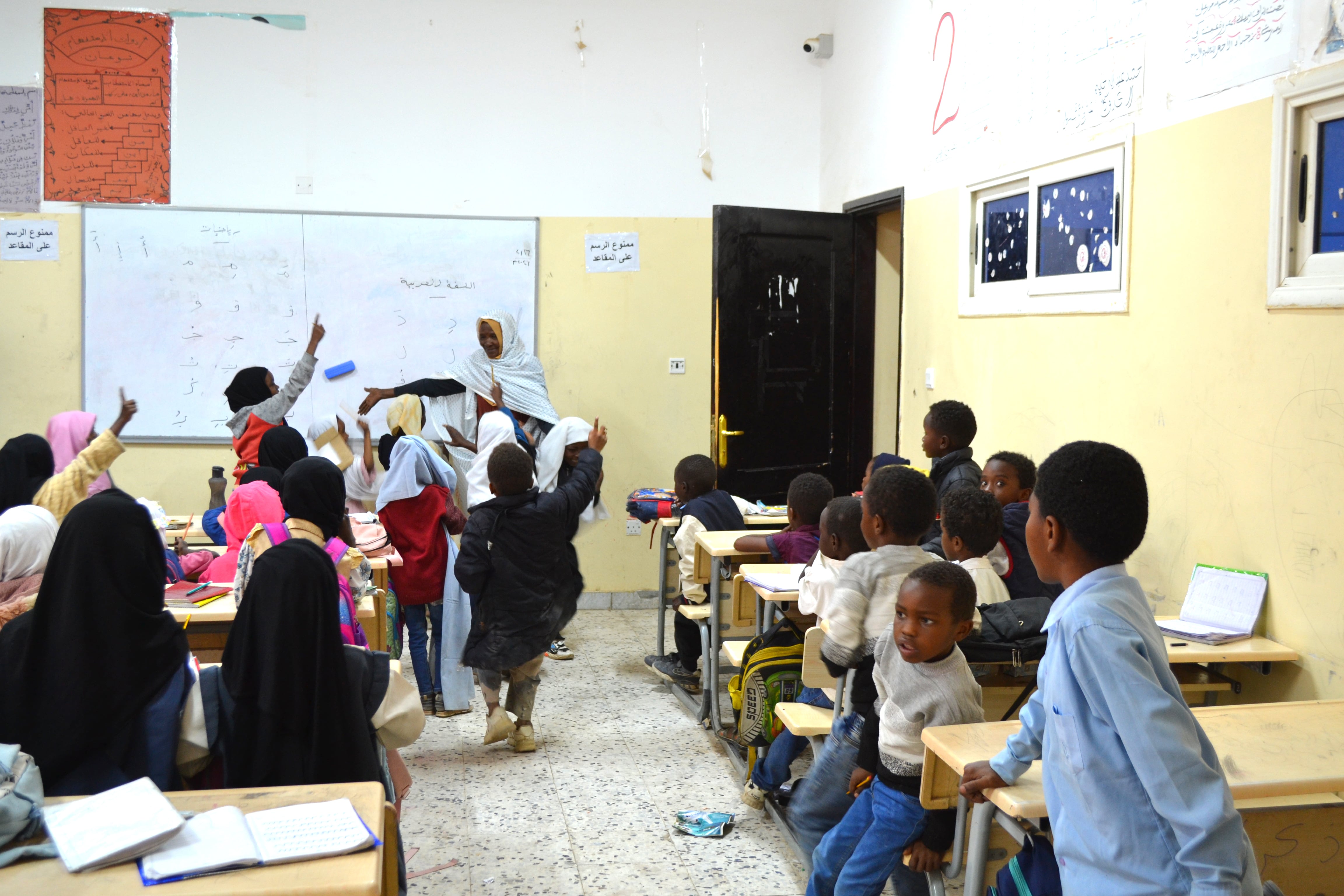 Unos 50 niños siguen esta clase de lectura de primer grado en la escuela Mártires de Al Ajhar. Solo la profesora tiene un libro.