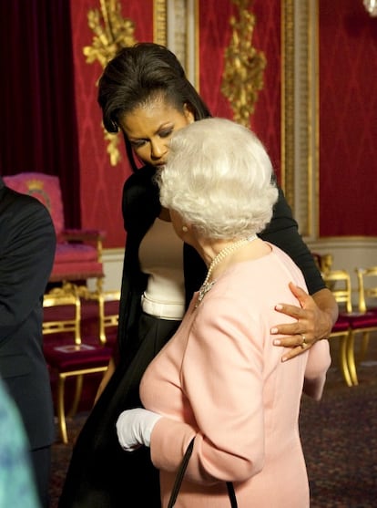 La primera dama de EE UU, posa su mano sobre la reina Isabel II, durante una recepción en el Palacio de Buckingham, el 1 de abril de 2009. Este gesto de cariño recibió ciertas críticas, ya que el estricto protocolo de la casa real limita el contacto con la reina en actos públicos.
