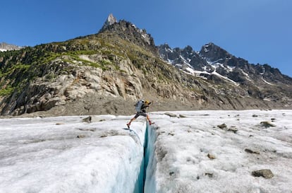 Una alpinista salta sobre una grieta del glaciar Mer de Glace, en la ladera norte del Mont Blanc.
