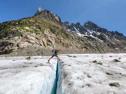 Una alpinista salta sobre una grieta del glaciar Mer de Glace, en la ladera norte del Mont Blanc.