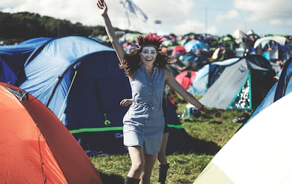 Una mujer en un festival de música de verano con la cara pintada, en un campamento. 