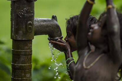 Unos niños beben agua de un pozo en Madhubani, en la región india de Bihar. Se trata de uno de los lugares más afectados por las inundaciones en la provincia. Este tipo de pozos son la única fuente de agua segura de la población.