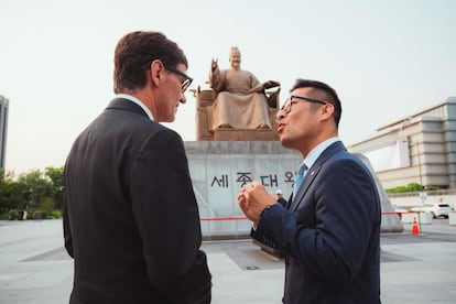 El 'president' Illa junto al delegado de Corea del Sur, Bekiu Kim Jung, junto a la escultura del padre del idioma coreano / ARNAU CARBONELL