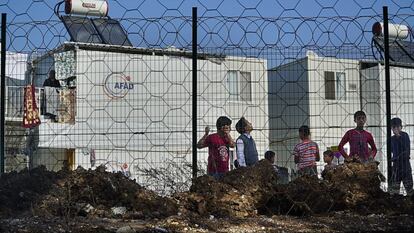 Niños de un campo de refugiados sirios observan el inicio de las obras de una escuela financiada por la UE en la provincia de Osmaniye (sur de Turquía).


