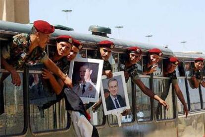 Militares sirios muestran retratos de Bachar el Asad y de su padre, Hafez, al regresar de Líbano en abril de 2005.