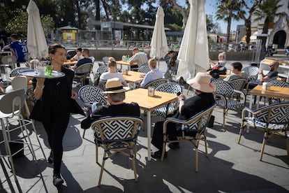 DVD1254 (20/02/2025). Sevilla. Una camarera atiende una terraza con turistas en Sevilla. FOTO: PACO PUENTES (EL PAÍS)