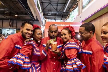 Fran, a cocktail expert from Dominican Republic, prepares a mango cocktail accompanied by men and women dressed in the country’s traditional costumes. He has also prepared another cocktail called “it has everything.”