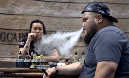 Dos personas fuman cigarrillos electrónicos en un encuentro para vapeadores en Las Vegas.