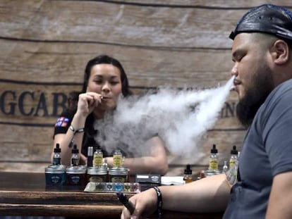 Dos personas fuman cigarrillos electrónicos en un encuentro para vapeadores en Las Vegas.