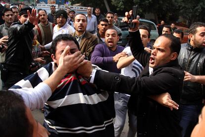 Um oficial de segurança vestidos de civil, com uma pistola, para um partidário do presidente islamista deposto Mohammed Morsi.