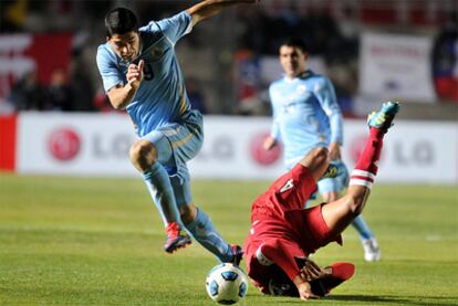 Luis Suárez trata de llevarse el balón ante el rival de Perú.