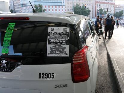 Un taxi en Madrid con uno de los carteles de la huelga de este martes.