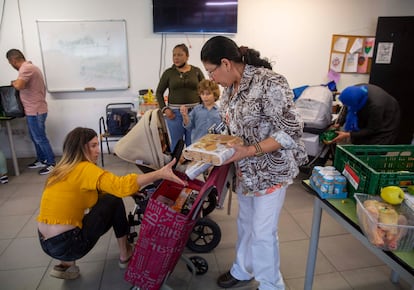 Cony Platero, en el centro, recoge alimentos este miércoles en el local de la ONG Esperanza Latina de San Sebastián.