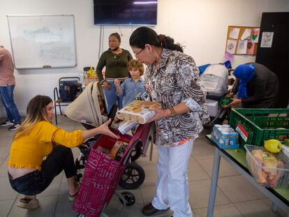 Cony Platero, en el centro, recoge alimentos este miércoles en el local de la ONG Esperanza Latina de San Sebastián.