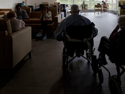 Residentes de un centro de mayores de la Comunidad de Madrid charlan y descansan en un salón del centro.