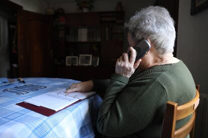 Una mujer habla por teléfono en su casa.