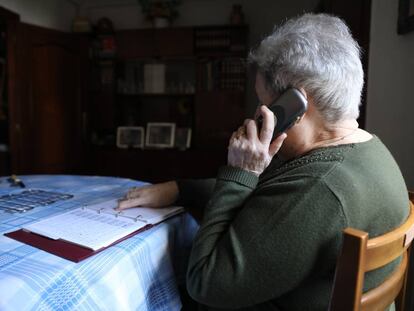 Una mujer habla por teléfono en su casa.