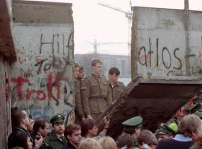 Guardas fronterizos de la República Democrática Alemana observan el derribo del muro de Berlín, en 1989.