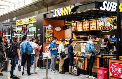 Ciudadanos chinos hacen cola en un restaurante de comida rápida en una estación de tren de Sanghái. 