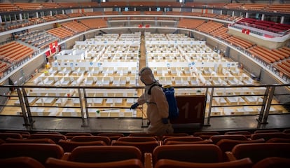 En la imagen, un empleado rocía con desinfectante el interior de este hospital de campaña en el estadio deportivo de Wuhan, el epicentro de la pandemia en China. Si las camas están vacías es porque esta fotografía se tomó cuando el último de los pacientes del centro fue dado de alta. Foto del 8 de marzo.