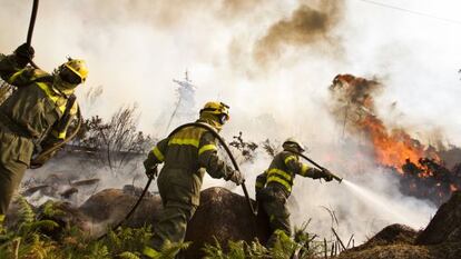 Firefighters try to extinguish the blaze in Monte Pindo.
