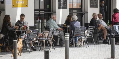 Personas consumiendo en los veladores de un bar abierto durante el segundo día de la fase 1 del plan de desescalada que ha elaborado el Gobierno de España. 