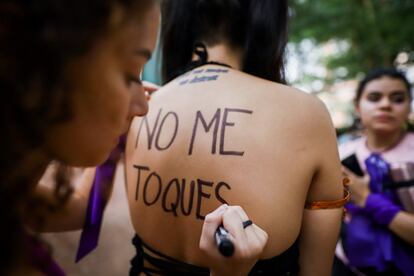 Una mujer escribe en la espalda de una manifestante "No me toques", en el transcurso de una marcha para reivindicar la igualdad en Asuncin (Paraguay).