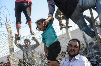 Esta foto, publicada en junio en EL PAÍS y otros medios internacionales, corresponde a uno de los episodios más tensos de la crisis de refugiados sirios. Los asilados entran en Turquia tras romper la valla que le separa de Siria. Es el tercer premio en el apartado de historias TERCER PREMIO EN HISTORIAS DE NOTICIAS DE ACTUALIDAD