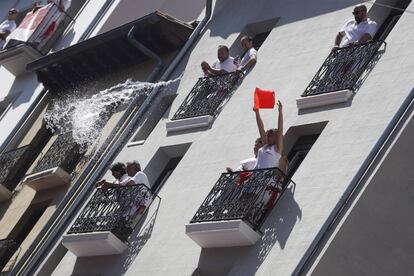 Uma mulher lança um balde de água de uma janela durante a abertura oficial da festa de São Firmino, neste sábado, em Pamplona.