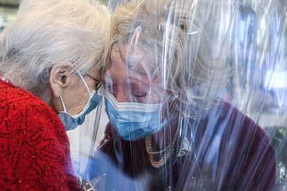 Una anciana besa a su hija a través de una pantalla de plástico en una residencia de ancianos en Castelfranco Veneto (Italia). Italia superó el umbral del millón de casos confirmados de coronavirus y registró la muerte de casi 43.000 personas desde el inicio de la pandemia, según datos oficiales divulgados este miércoles.