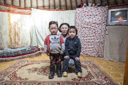 Lkhagvatungalag Tsogzolmaa posa con dos de sus hijos pequeños en el sencillo ger que les ha proporcionado World Vision.