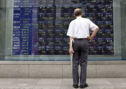 Un hombre observa una pantalla informativa en la que aparece información bursátil en Tokio. EFE/Archivo